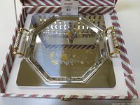 Octagonal serving tray with gold floral design and gold-tone handles in presentation box