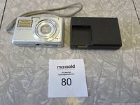 Sony Cybershot DSC S950 camera and separate battery charger on a table.