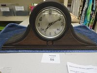 Front view of vintage New Haven Tambour mantel clock showing clock face and wood case.