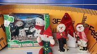 Boxed Double Dancing Snowmen with two free-standing snowman figures and the Elf on the Shelf figure visible on a shelf with measuring tape backdrop