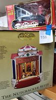 Both items boxed: battery operated Big Rig Loco train and Gold Label Collection Nutcracker Suite musical display showing front of boxes.