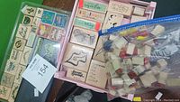 Various wooden stamps in boxes including alphabet, punctuation, and phrases alongside a bag of smaller stamps and blank wood blocks, with a stamp pad included.