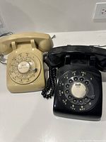 Both rotary dial phones side-by-side, showing their overall form and handset placement