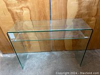Front angle view of a transparent glass console table with rounded edges
