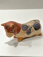 Side view of the hand-painted Tonala pottery bull showing detailed brushwork and burnished finish.