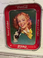 Front view of vintage Coca Cola metal serving tray showing central image, border text and condition