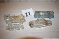 Four vintage glass candy containers displayed together on a table, showing shapes and relative sizes