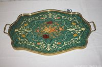 Full view of vintage tray showing green surface with floral designs, brass perforated edge, and handles