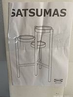 Cover page of Ikea Satsumas plant stand instruction manual showing line drawing of the assembled 3-tier plant stand.