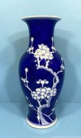 Porcelain vase with cobalt blue glaze and white floral branch patterns, shown from side view