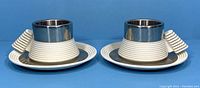 Two espresso cups and saucers showing front and side angles