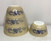 Four vintage Pyrex Homestead mixing bowls nested upside down stacked with pattern visible