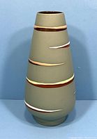 Front view of vintage West German pottery vase showing olive green matte finish and multicolor raised stripes.