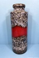 Front view of the tall vintage pottery vase showing textured speckled glaze with red diagonal band.