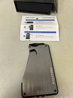 Brushed metal RFID wallet, showing the lever and 'FANTOM' branding in front of a plain background.