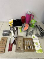 Full lot spread showing knives, pink tumbler, box cheese tools, spatulas, whisks, etc.