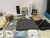 Overview showing all items in the lot including boxed and unboxed kitchen accessories, cleaning products, and garbage bags.