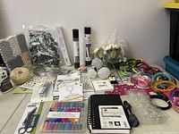 Wide view of the assorted new craft supplies showing vinyl rolls, markers, floral embellishments, ribbons, and other materials.