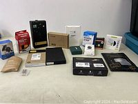 View of various new, untested electronic accessories and chargers on a table with some packaging damage.