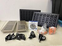 Overview photo showing castor wheels, vent covers, push button doorbell box, and orange garage utility hooks.