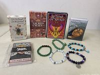 Lot setup showing all five oracle/tarot card decks and six bracelets arrayed