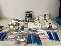 Photo of yarn skeins, sewing tools, needles, scissors and embroidery hoops spread out on a table.