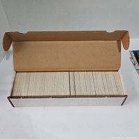 Open box showing large quantity of trading cards neatly stacked inside.