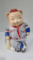 Front view of ceramic bear cookie jar in baseball attire, holding bat, labeled 'Bear Team'.