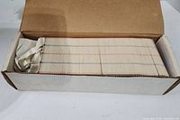 Box filled with a large quantity of hockey cards stacked neatly inside, showing edges of cards with colored stripes.