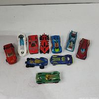 Lot of 10 assorted toy cars arranged in a single row showing front and side views.