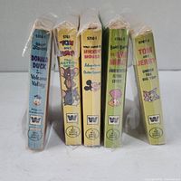 Five vintage Little Golden Books standing upright showing titles on spines in shrink wrap