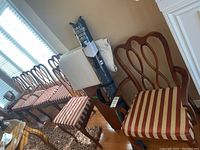 Six chairs arranged in a row showing matching striped seats and wood frames