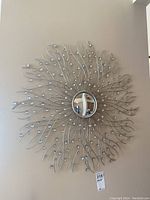 Full frontal view of decorative sunburst mirror hanging on wall