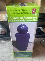 Box showing image and model name of the blue ball fountain by President's Choice