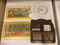 Overview photo showing two framed prints, a round clock, and a wooden wall organizer displayed on a flat surface.