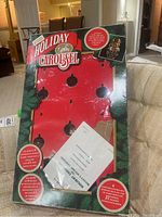 Full view of the original box packaging with cutouts showing carousel figure positions and holiday graphics.