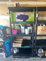 Full view of black plastic modular shelf with empty shelves and some items around it for reference.