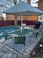 Full set of green outdoor table, chairs, umbrella, and stand on patio