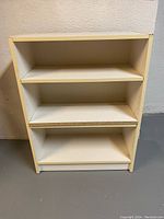 Full view of white shelving unit showing three shelves, light wear, approximately 32 inches tall