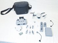 Overall view of drone, controller, batteries, spare propellers, sticks, charger, cables and case