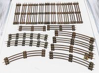 Photo showing all 13 pieces of vintage Lionel 3-rail metal model train track, including straight and curved sections arranged on a white surface.