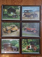 Overview photo showing all six framed vintage automobile photographs arranged on a wooden floor.