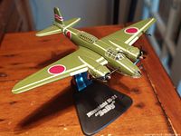 Green Mitsubishi Ki-21 'Sally' scale model airplane on black display stand from an angled side view.