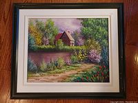 Framed oil painting showing entire artwork and frame, depicting a countryside cottage scene with a pathway and floral surroundings.