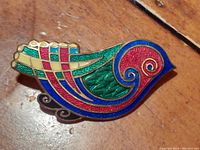 Front view of vintage cloisonne bird brooch showing detailed enamel sections in red, green, blue, yellow and gold wire outlines.