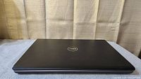 Dell Studio 1737 laptop closed, showing black Dell logo on lid, indicative of condition and model.