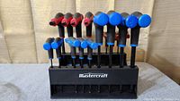 Front view of Mastercraft T-handle hex key set in black stand showing keys with blue and red handles arranged by size.