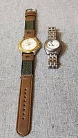 Pair of two golf watches, men's and ladies', shown side by side on fabric surface