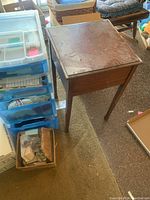 Overview of plastic drawers, wooden table and boxes showing lot containers