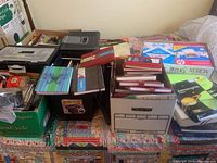 Wide view of lot showing multiple boxes and containers full of new journals, file folders, printer paper, storage boxes, and other office supplies.